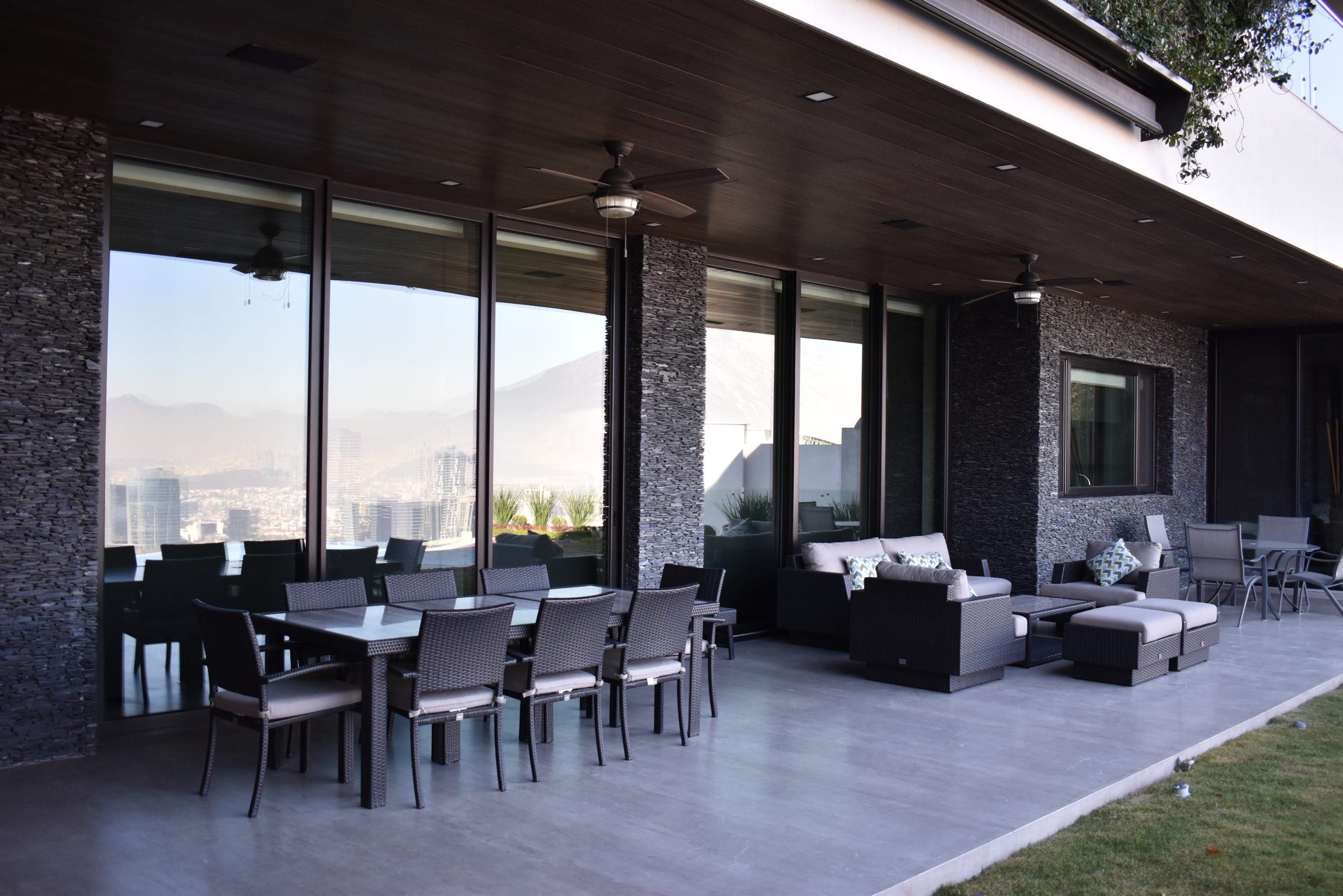 Vista exterior de ventanas grandes de una sala moderna con vista al patio