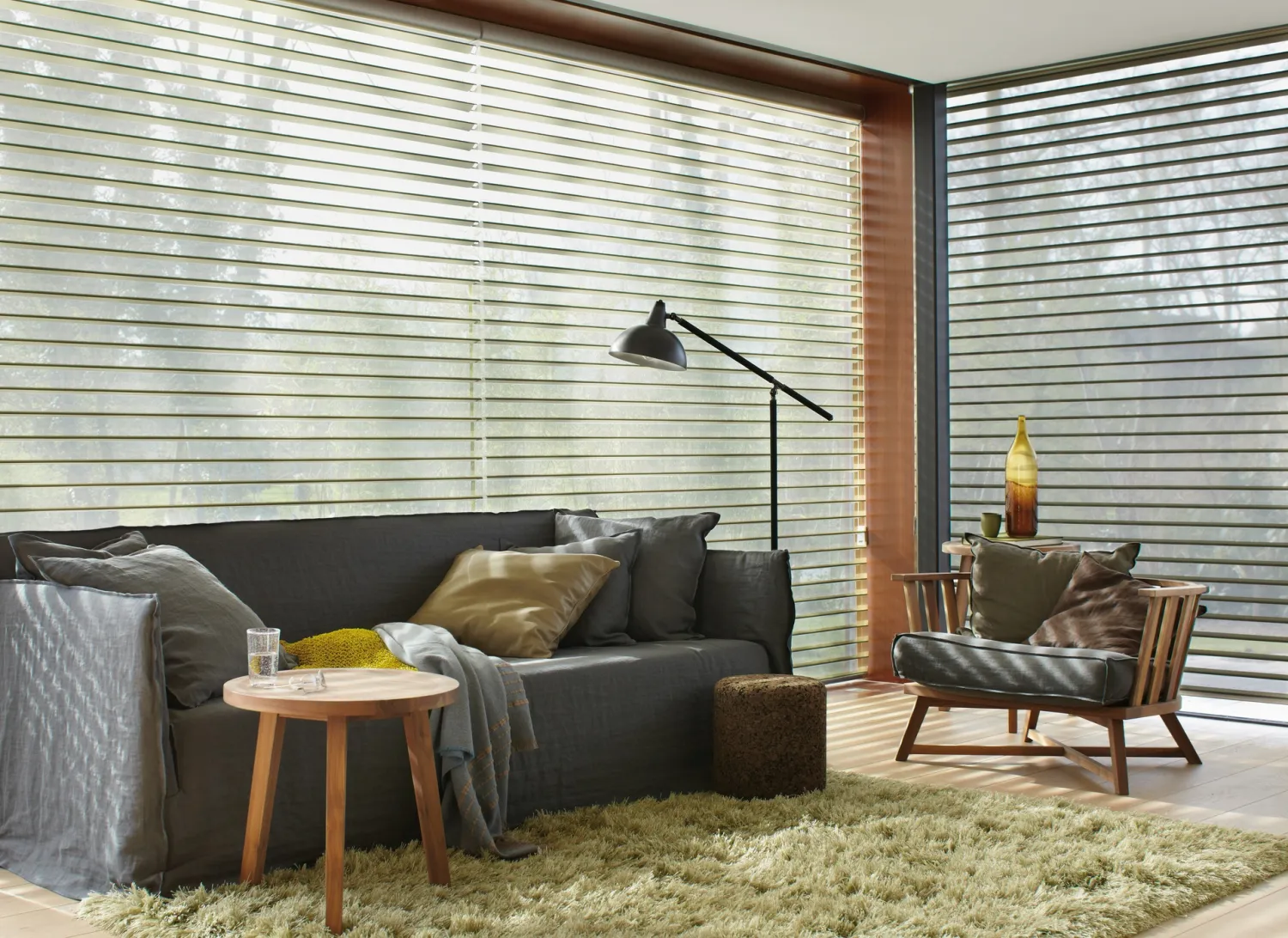 Ambiente de sala elegante donde destacan las persianas tras el sillón