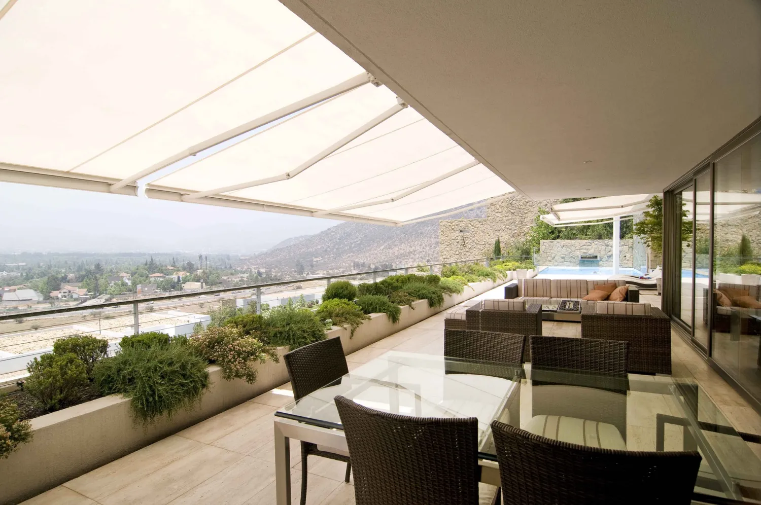Terraza moderna con toldo proporcionando sombra y confort al aire libre