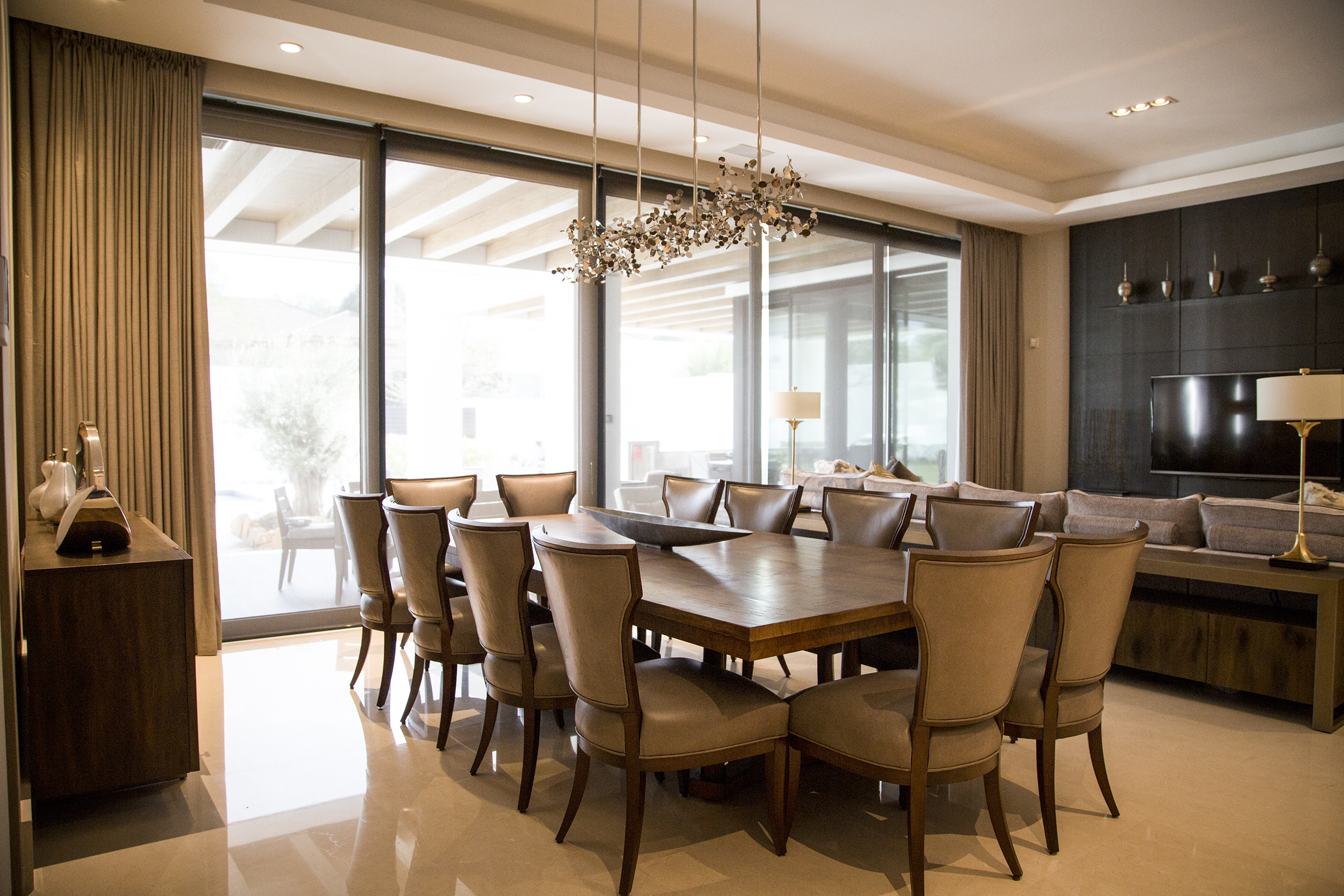 Comedor elegante con ventanas grandes y cortinas de tela en el fondo que aportan calidez y estilo al espacio